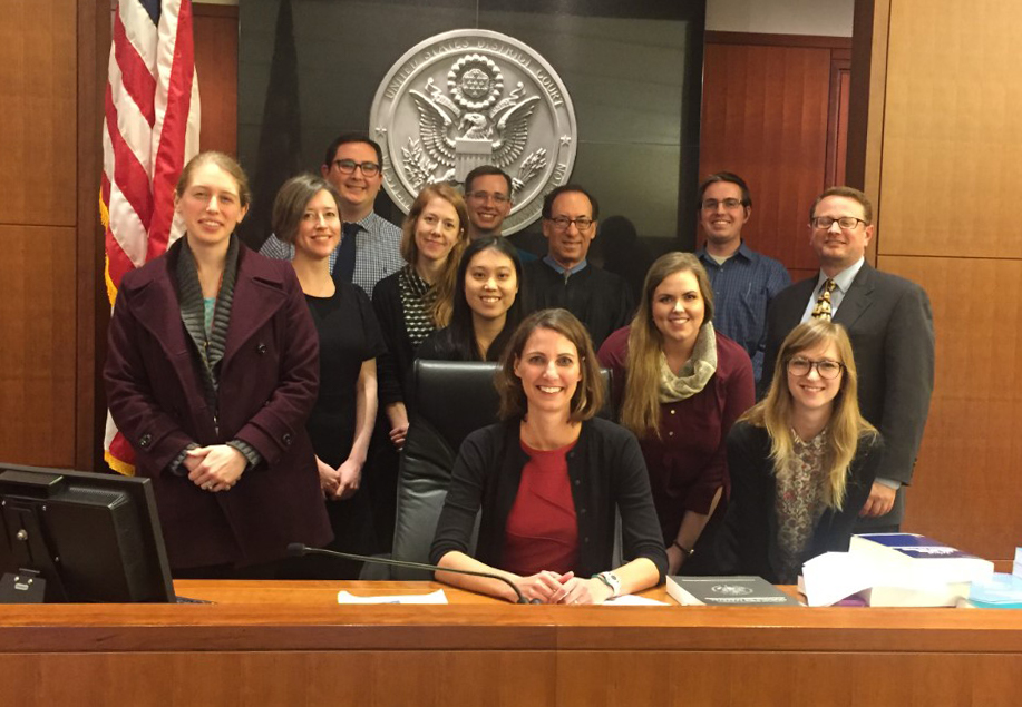 Jennifer Piel, University of Washington residents, and other attorneys, pose in a courtroom during a mock trial activity. 